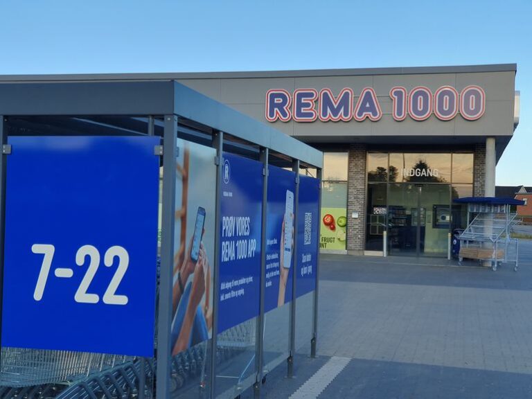 REMA 1000 åbningstider: skilt med 7-22 ved indgangen til en butik